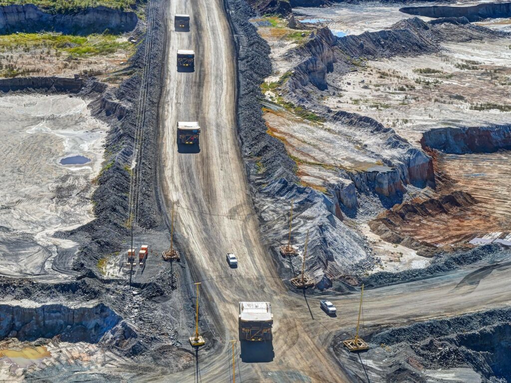 Mine vehicles traveling down a sandy road